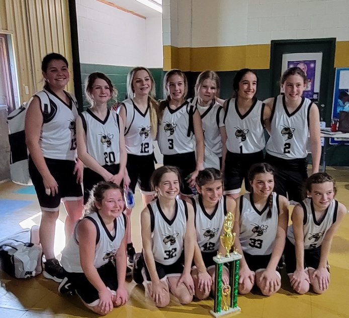 Kali Hinson's basketball team posing with a championship trophy