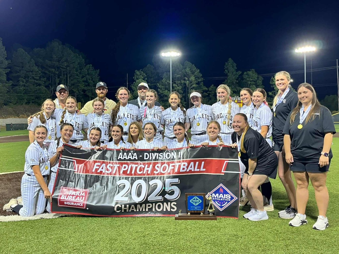 Oak Forest Academy softball team celebrating their 2025 4A state championship with the championship banner and trophy
